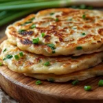 Trader Joe’s scallion pancakes served with soy sauce and chili oil on a rustic wooden board